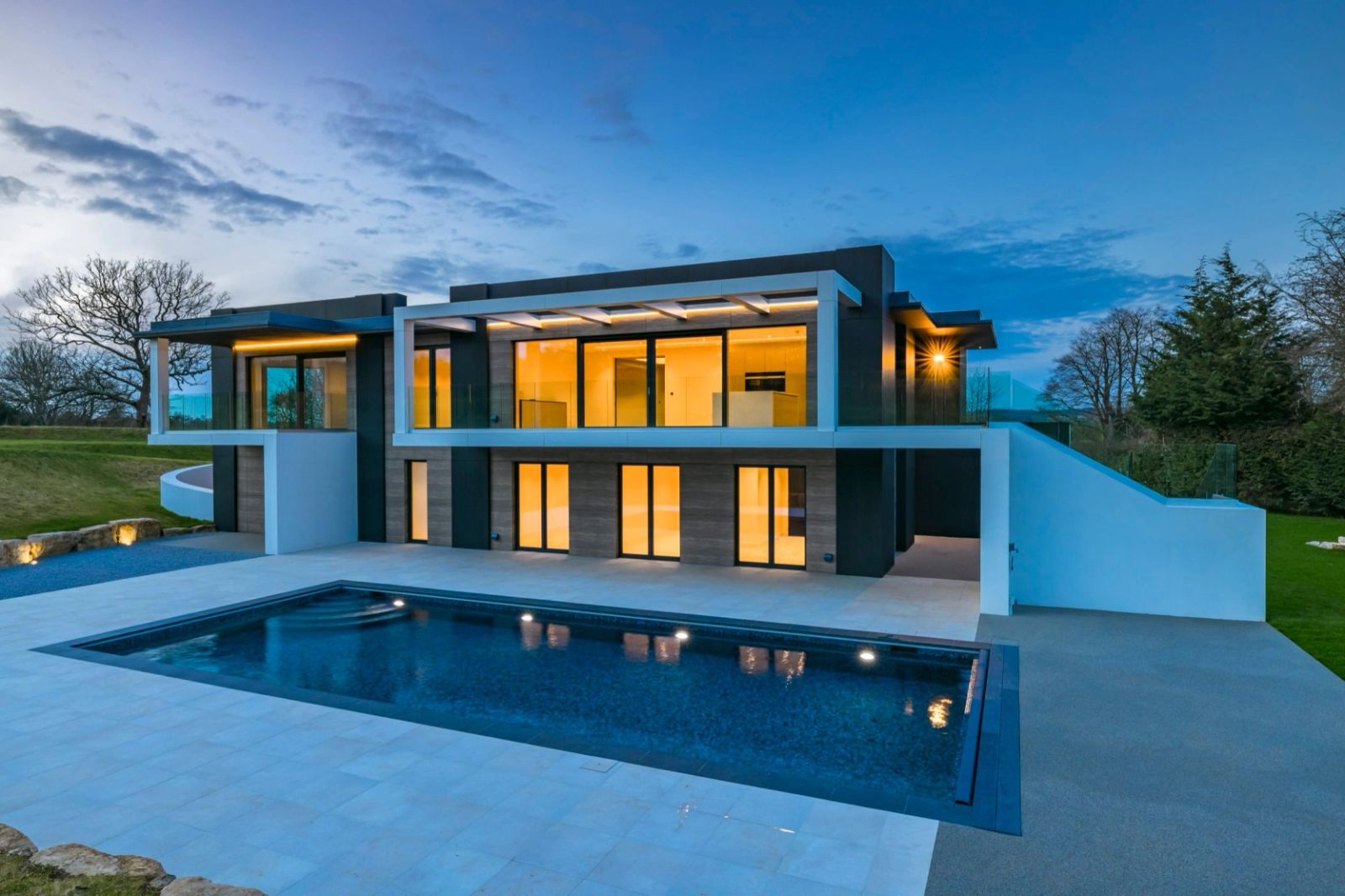 Contemporary home at dusk with integrated architectural and pool lighting